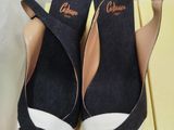 pair of black and white wedged shoes on a yellow box