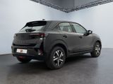 the rear end of a grey car in a large room