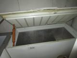 a small white refrigerator with a door open in a room