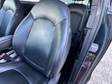 l'intérieur d'une voiture avec des sièges en cuir noir et des garnitures en cuir noir