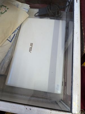 un ordinateur portable blanc exposé dans une vitrine en verre