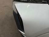 the front end of a white car with a denting dent