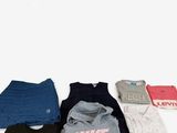 de nombreux t-shirts étalés sur une surface blanche