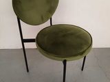 a green chair with black legs and a round seat