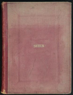 un vieux livre à la couverture rose posé sur une table