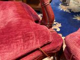 two red chairs that are sitting on a blue rug