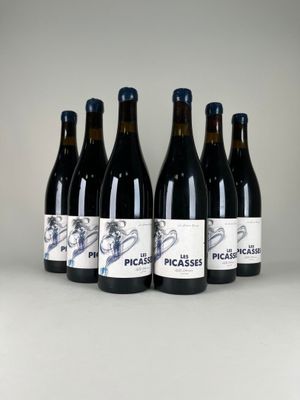 six bouteilles de vin sont alignées sur une table