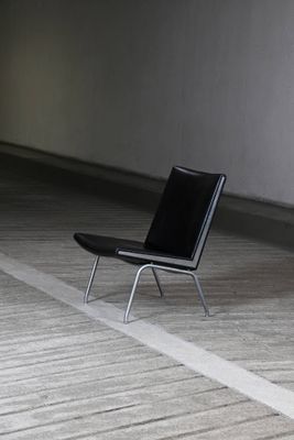 une chaise noire qui se trouve au milieu d'une pièce