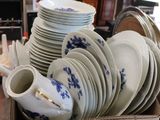 many plates and cups in a box on a table