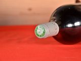 a bottle of wine sitting on a table with a red cloth