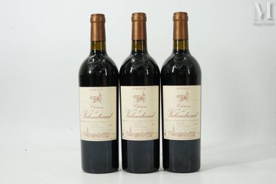trois bouteilles de vin posées sur une table blanche