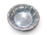 une assiette en argent posée sur une surface blanche