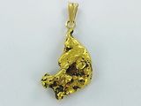 gros plan d'un pendentif en or sur une surface blanche