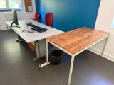 un bureau sur lequel se trouve un ordinateur, dans une pièce aux murs bleus
