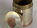 a silver cup with a copper lid sitting on a table
