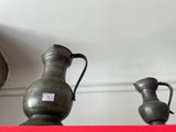 trois vases posés sur une étagère dans une pièce