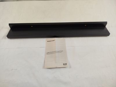 an image of a black shelf with a piece of paper on top of it