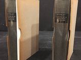 pair of vintage books in cardboard boxes on a black surface