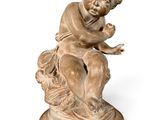 a small statue of a boy sitting on a pedestal