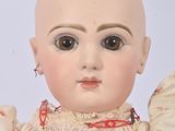 a doll with a bald head wearing a dress