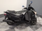 a black motorcycle parked in a room with a checkered floor