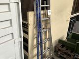 a ladder leaning up against a wall next to a pile of pallets