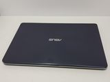 the back of a laptop computer sitting on top of a white table