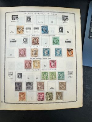 un livre ouvert, orné de timbres, à côté d'un ordinateur portable
