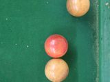 three apples that are sitting on a green table