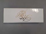 a white box with gold writing on it on a table