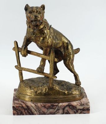 statue en bronze représentant un chien sautant par-dessus une clôture, posée sur un socle en marbre
