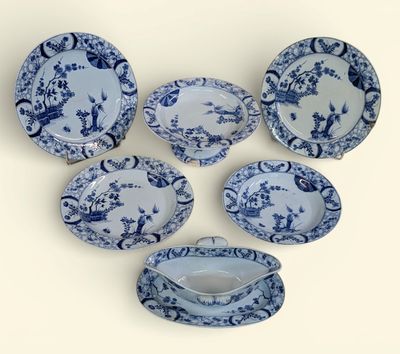 six pièces de vaisselle bleue et blanche posées sur un fond blanc