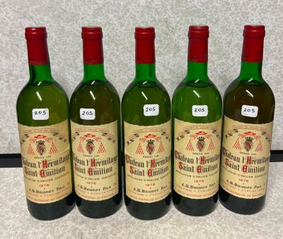 quatre bouteilles de vin sont alignées sur un comptoir