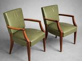 deux fauteuils en cuir vert avec des accoudoirs en bois