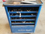 un chariot à outils bleu, chargé d'outils, dans un garage