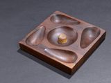 a wooden plate with a bowl on it on a table