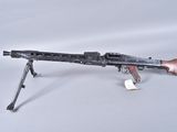 an old machine gun with a wooden barrel on a white surface