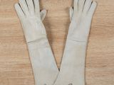 two pairs of white leather gloves on a wooden surface