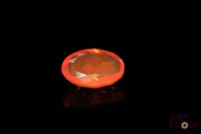 an orange diamond on a black surface with a black background