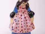 a figurine of a woman in a pink dress and hat