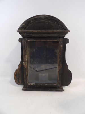 une petite horloge en bois posée sur une surface blanche
