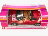 une petite voiture rouge dans une boîte rose posée sur une surface blanche