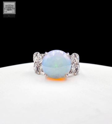 an oplite and diamond ring on a white plate