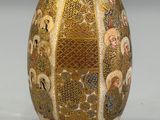 a vase that has a gold and white design on it