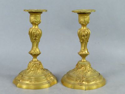 pair of antique brass candlesticks on pedestals on white background