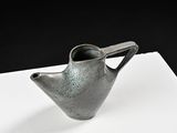 a small gray vase sitting on top of a piece of paper