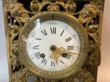 a gold clock with a bird on top of it