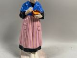 une figurine représentant une femme tenant une assiette de nourriture