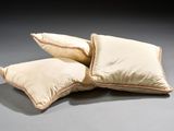 three pillows sitting on top of each other on a gray surface