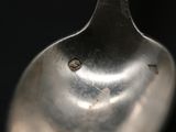 a close up of a silver spoon with a hole in it